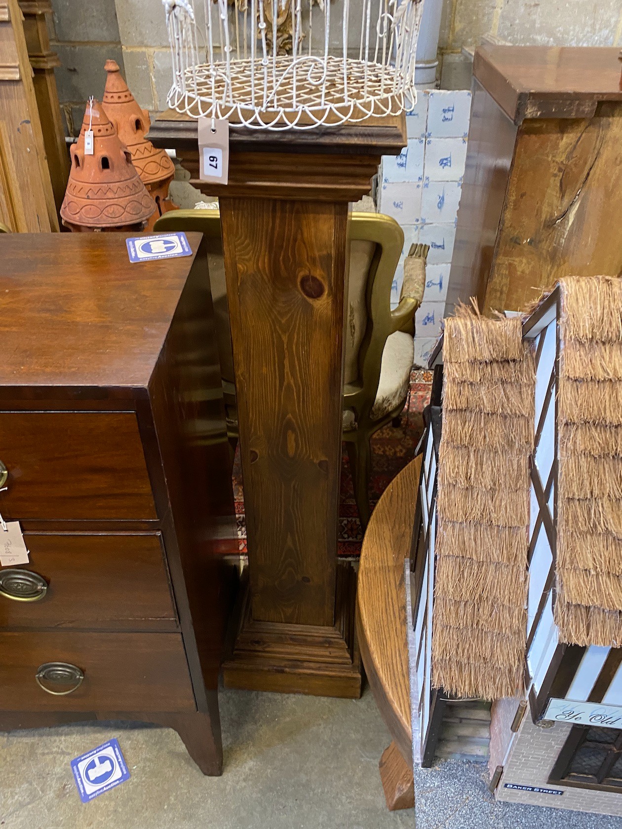 A stained pine pedestal with wirework bird cage, total height 174cm